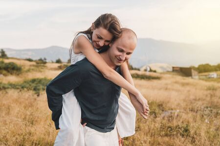 Young couple married in love man and woman young girl boyfriend husband is holding her on the...