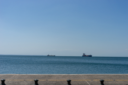Nikis street in thessaloniki view to the sea and harbor port from the sidewalk with ships on the horizonのeditorial素材