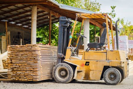 Fork lifter loaded with construction material plank framework at the building site
