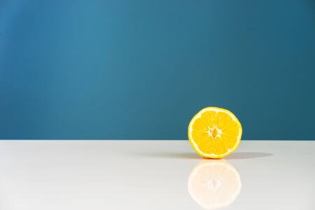Yellow ripe lemon sliced in half juicy citrus fruit on the white table in front of the blue...