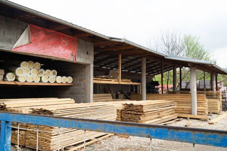 Warehouse in day full of timber planks on pile stack and construction material storehouse depot staple timber yard in dayの写真素材