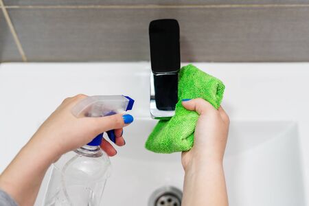 Top view on female hands holding cloth and spray sanitizer disinfection alcohol in hand cleaning...