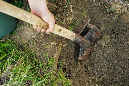Close up on shovel spade digging in soil dirt unknown caucasian man dig a hole in the field or...