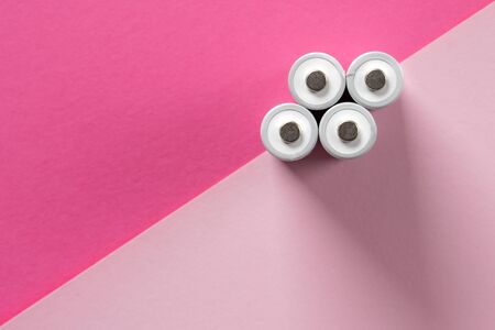 Top view on group of batteries on pink background summer minimalistic concept and layout pastel...