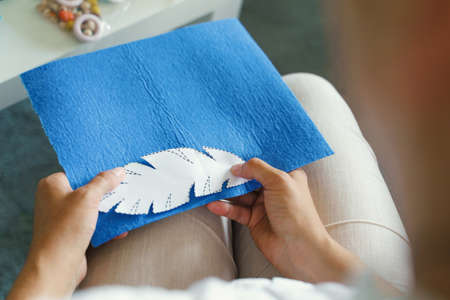 Close up on hands of unknown caucasian woman working art craft at home - Creative female hold paper...