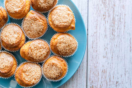 Close up top view on fresh homemade corn pone muffins in blue plate on wooden rustic table background with copy spaceの写真素材