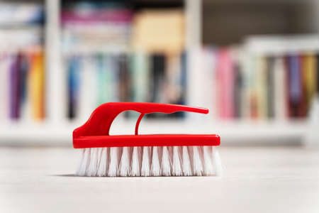 Close up on red scrub cleaning brush on the floor at homeの写真素材
