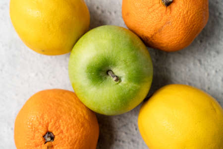 Top view on green apple granny smith with oranges and lemon on marble table - healthy organic eating fresh food rich in vitaminsの写真素材