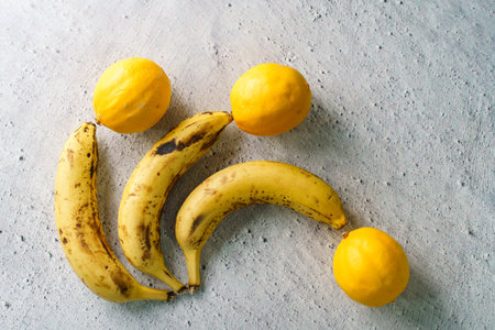 Ripe bananas and lemon on the table minimalistic detail fruit conceptの写真素材