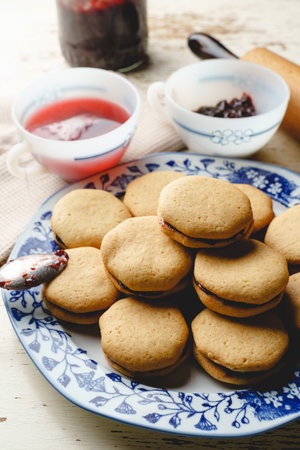 Homemade cookies with marmalade or fruit plum jam in a plate - close up front view baked sweet food...