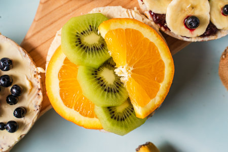 Crispy puffed rice cakes on table with fresh fruit kiwi banana and orange on the table - top view on healthy organic vegetarian or vegan breakfast gluten freeの写真素材