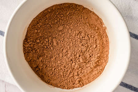 Close up top view on brown cocoa powder in a bowlの写真素材