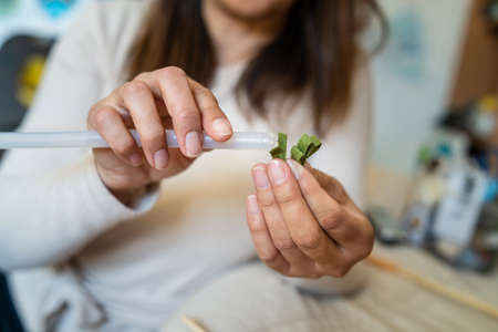 Close up on hands of unknown caucasian woman making decorative products at home leisure activity hobby arts and craftsの写真素材