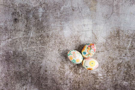 Top down flat lay view on easter eggs painted and decorated on marble background with copy space