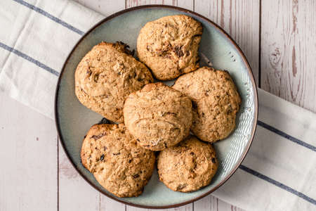 Close up top view on crunchy oatmeal chip cookies fresh baked biscuits with chocolate and cocoa in a...