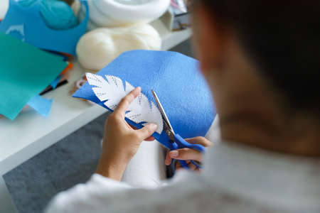 Close up on hands of unknown caucasian woman using scissors at home - Creative female cutting fabric adjusting pattern handmade tool craft making decoration - Creativity hobby and leisure conceptの写真素材