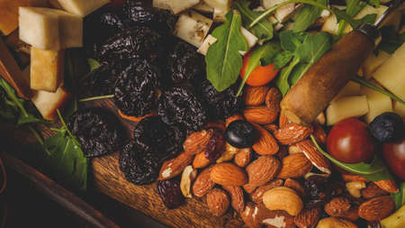Top view on the dry plum and almond on the wooden boardの写真素材