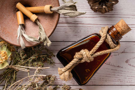 Top down view on various herbs and essential oil for mind body and soul healing homeopathy alternative medicine on wooden table with copy spaceの写真素材
