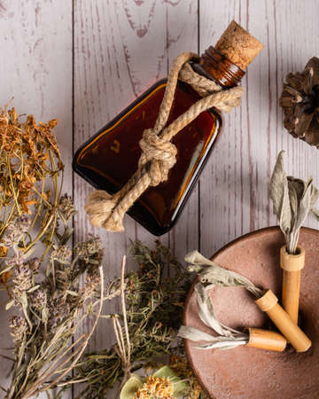 Top down view on various herbs and essential oil for mind body and soul healing homeopathy alternative medicine on wooden table with copy spaceの写真素材