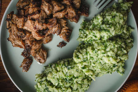 Beef and rice with spinach prepared meal in plate on the table ready to eatの写真素材