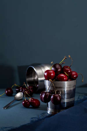 Red Cherries On Stainless Steel Pot, blue backgroundの写真素材