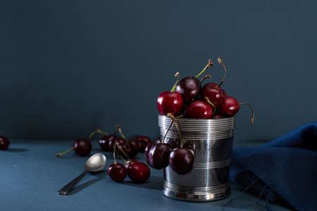 Red Cherries On Stainless Steel Pot, blue backgroundの写真素材