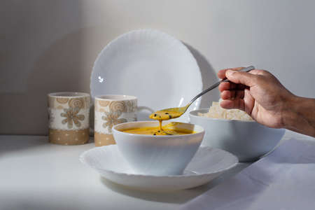 Delicious south Indian style mango curry with white rice, white background, handsの写真素材