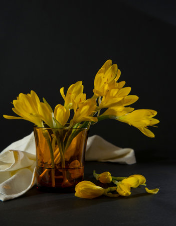 Still life Photography Yellow Lily Flowers, Yellow lily flowers in a glass on a dark background,...