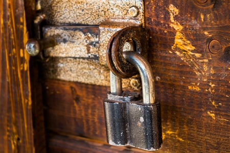 old wooden door closed on a large iron lock