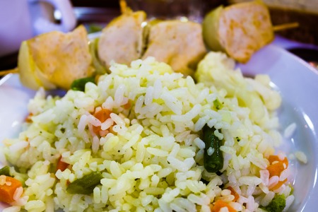 Rice with chicken and greens on the white plateの写真素材