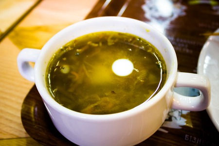 Vegetable soup in a white plate on a brown trayの写真素材