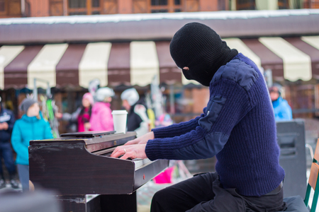 A pianist plays in a black mask on the streetの写真素材