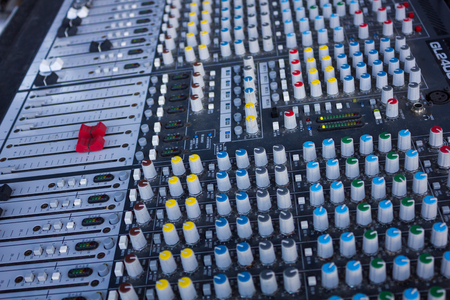 DJ mixer with lots of multi-colored buttons and knobsの写真素材