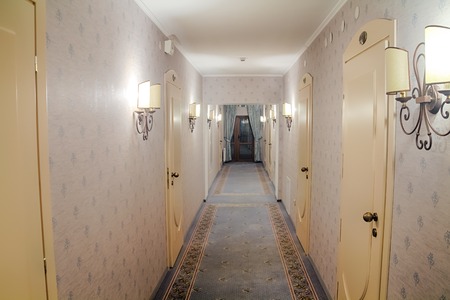 Corridor in the hotel in the evening with a variety of lamps and blue carpetの写真素材