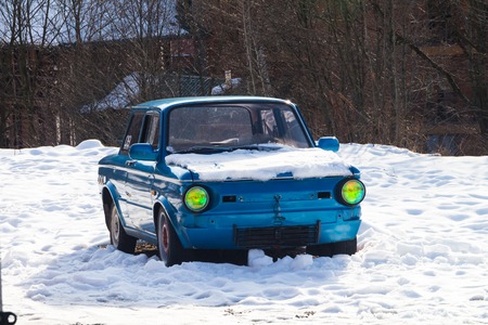 Blue retro car with original headlights winterの写真素材