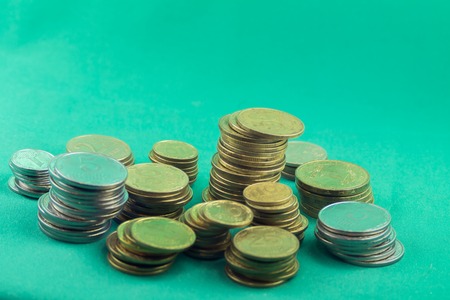 Lots of coins of different values on a green backgroundの写真素材