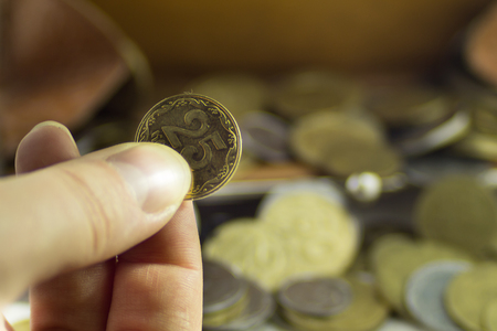 Lots of coins of different values on a white background  in brown leather walletsの写真素材