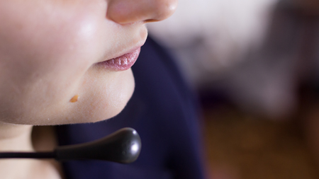 Beautiful girl in call center with headphones and microphone talking to customersの写真素材