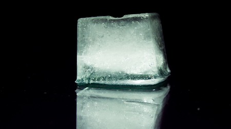 A piece of melted ice of thawing on a black background