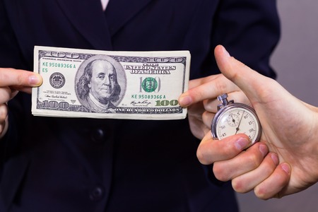 Money in the of women's hand and stopwatch in the man's hand