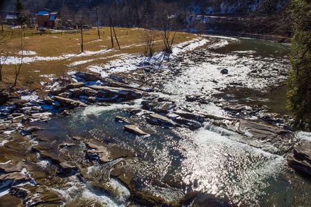 Beautiful view of the mountain river in the spring under the melting snowの写真素材