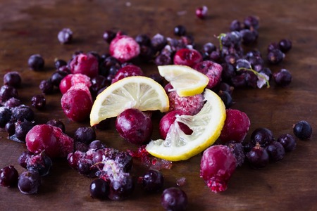Closeup of frozen cherries lemon slices and black currant covered by hoarfrostの写真素材