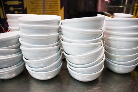 Pure white dishes is neatly standing in the cafeの写真素材