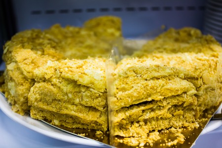 Large honey cake with gold powder on the counter