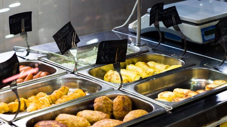 Counters with a diverse array of meat dishes in a cafeの写真素材