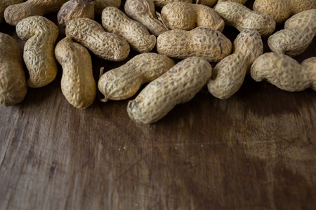 Peanut in a peel on a wooden backgroundの写真素材