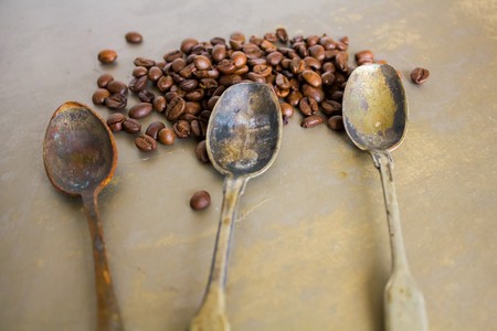 Vintage old rusty spoon and black coffee beansの写真素材