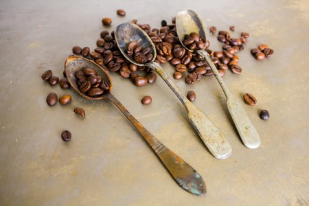 Vintage old rusty spoon and black coffee beansの写真素材
