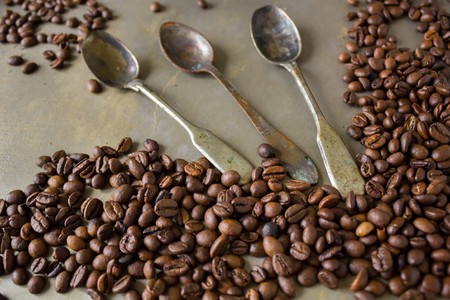 Vintage old rusty spoon and black coffee beans