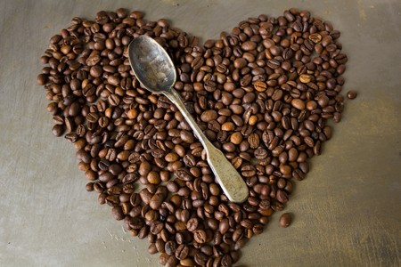 Big coffee heart made of grains vintage spoon on steel backgroundの写真素材